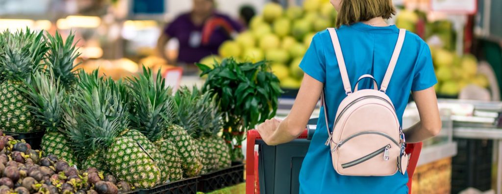 Mulher no supermercado usando o benefício alimentação